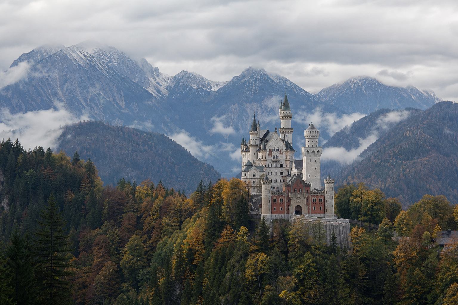 Schloss Neuschwanstein über Wald und Berghängen